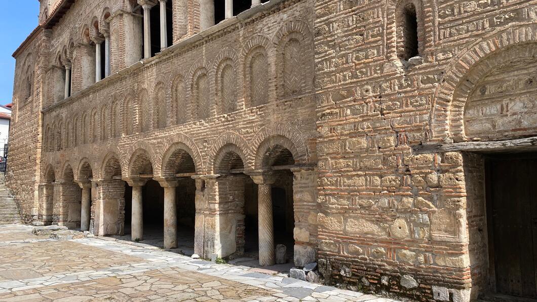 View of a brown stone building with many arches
