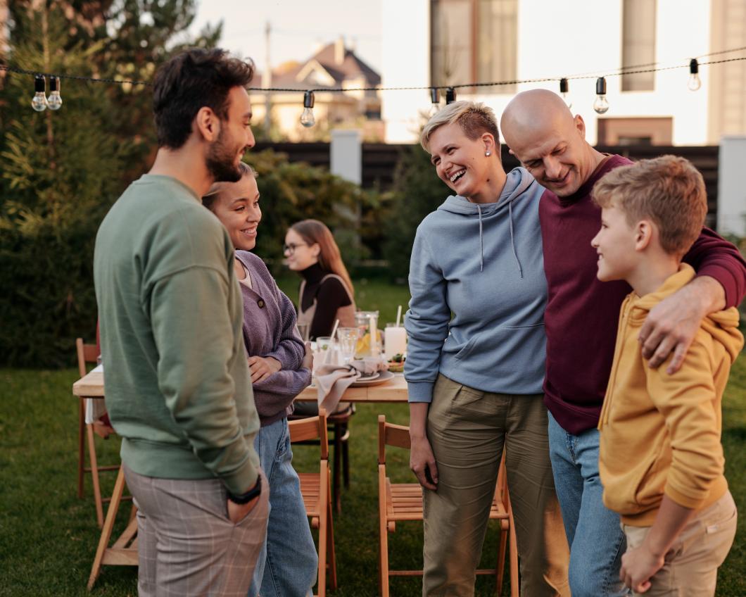 Mensen staan lachend buiten en knuffelen