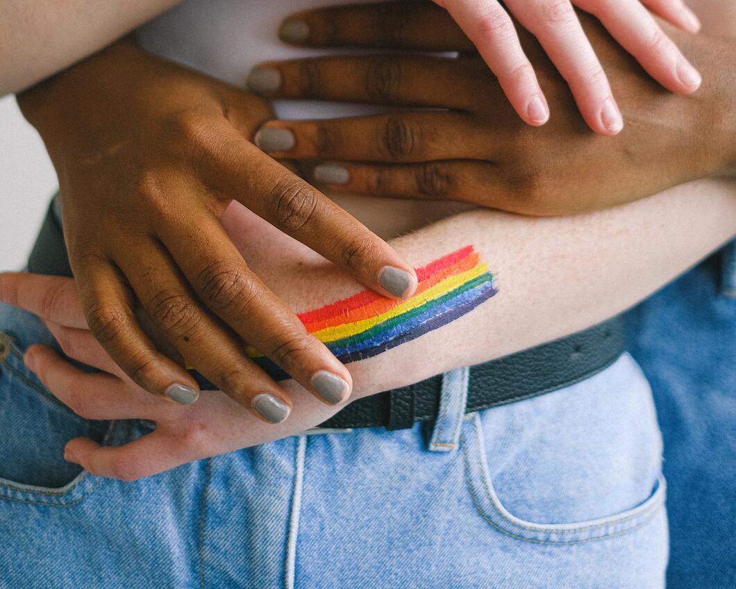vier regenboog handen op één buik