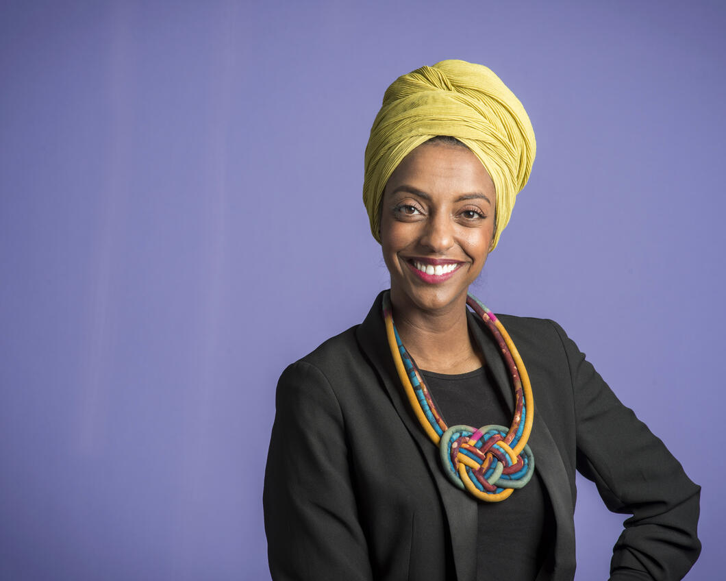 Milka Yemane voor een paarse achtergrond