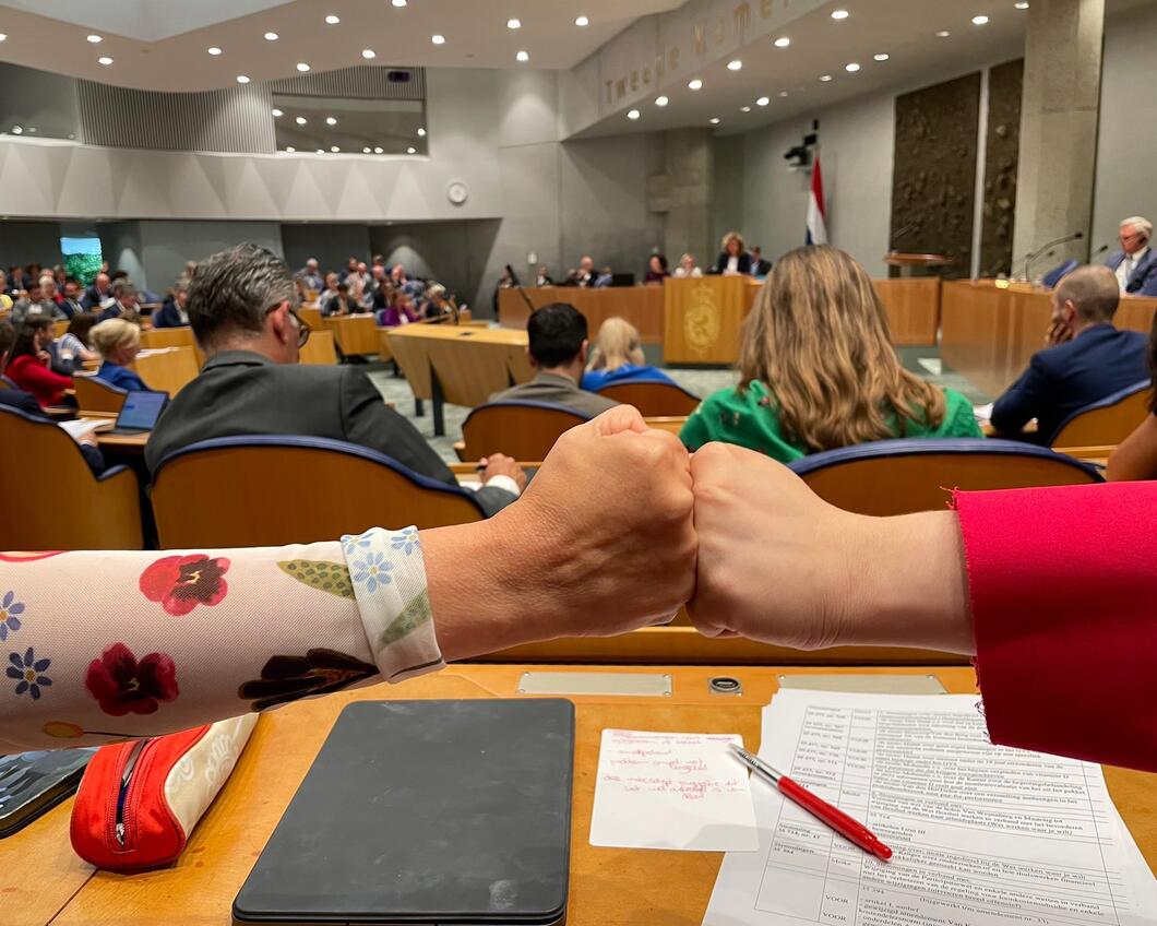 Kamerleden Laura Bromet en Senna Maatoug geven elkaar een boks in de Tweede Kamer
